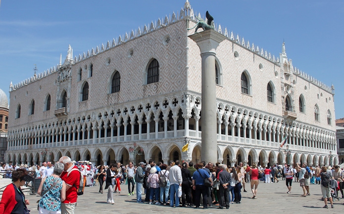 Tourists gather outside Doge's Palace in Venice during a walking tour.