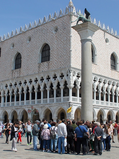 Tourists gather outside Doge's Palace in Venice during a walking tour.