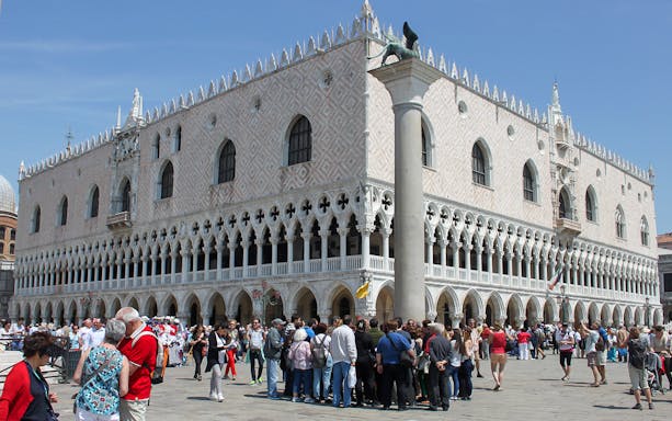 Tourists gather outside Doge's Palace in Venice during a walking tour.