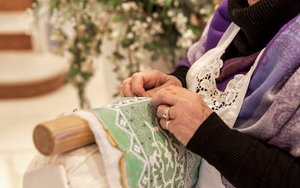 Lady embroidering lace on Burano, Venice tour.