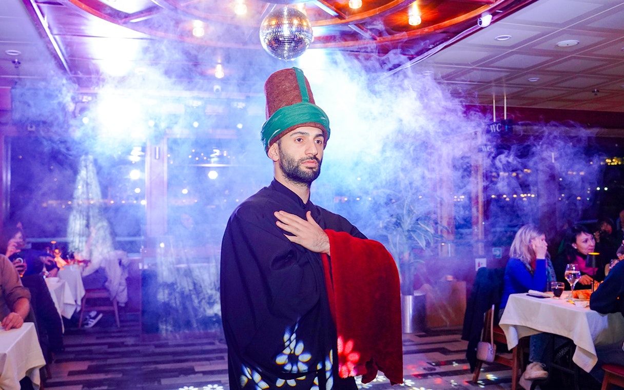 Whirling dervish performing on Bosphorus dinner cruise with live entertainment.