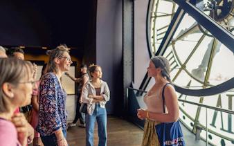Visitors inside Musée d’Orsay near the clock, Paris tour.
