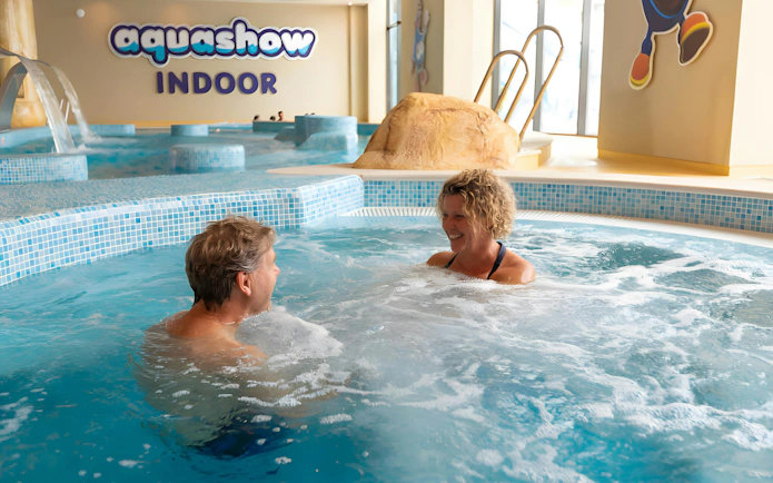 Couple enjoying a jacuzzi at Aquashow Indoor Park.