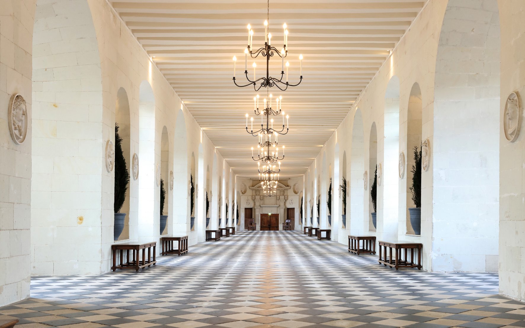 Grand hallway with chandeliers at Chenonceau Castle, France.