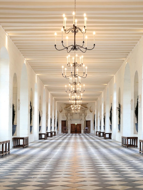 Grand hallway with chandeliers at Chenonceau Castle, France.