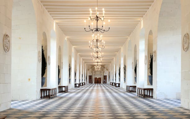 Grand hallway with chandeliers at Chenonceau Castle, France.