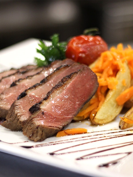 Sliced steak with potato wedges and carrots on Budapest Candlelit Dinner Cruise.