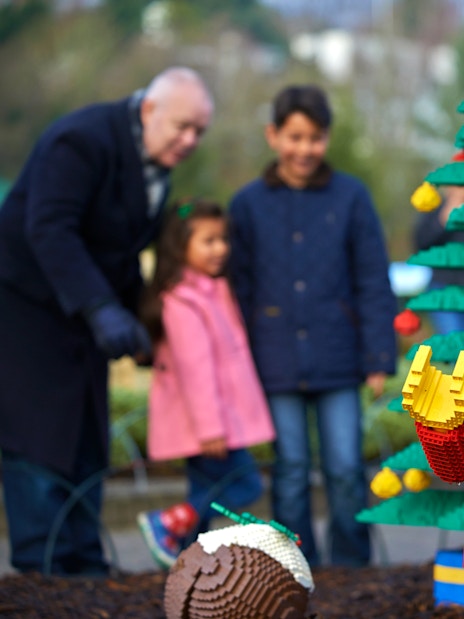 Lego elf sculpture with Christmas tree at Legoland London during holiday season.