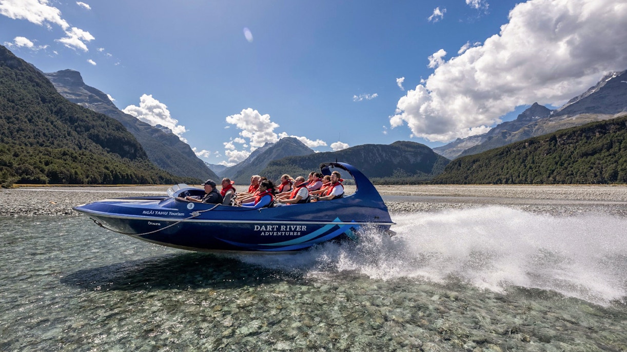 Jet boat on Dart River with tourists enjoying Funyak adventure in New Zealand.