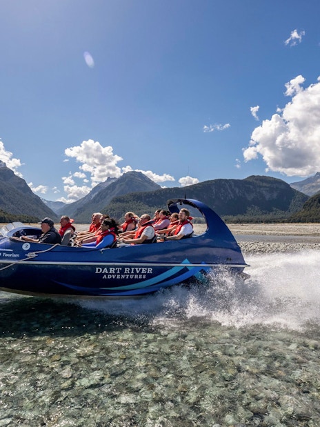 Jet boat on Dart River with tourists enjoying Funyak adventure in New Zealand.