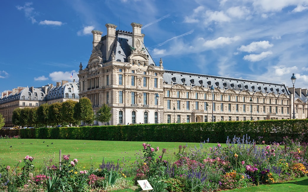 Louvre Museum exterior with gardens in Paris, France.