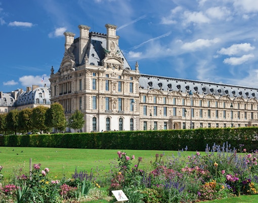 Guide leading tourists through Louvre Museum, viewing famous artworks in Paris, France.