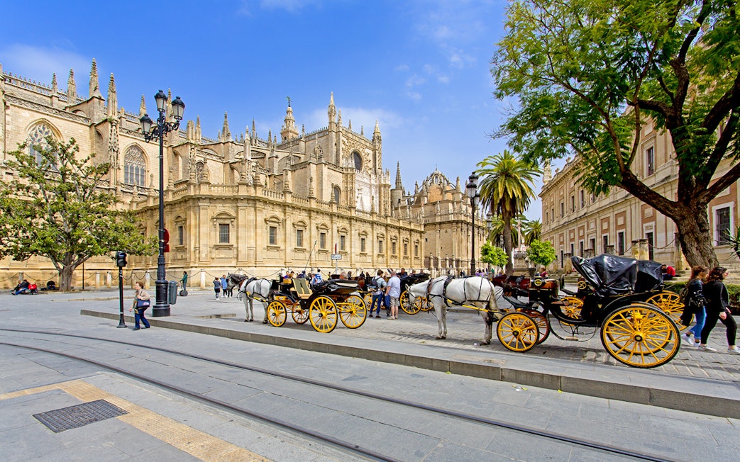 Horse-drawn carriages in front of Seville Cathedral, Spain.