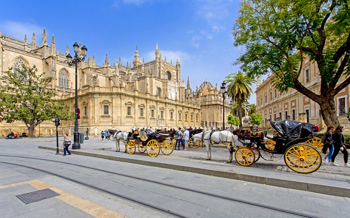 Horse-drawn carriages in front of Seville Cathedral, Spain.