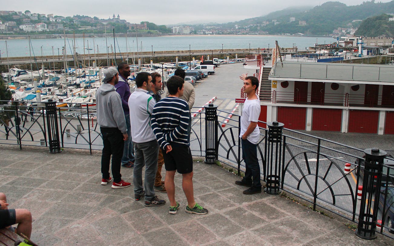 Group on a guided walking tour overlooking San Sebastian marina.