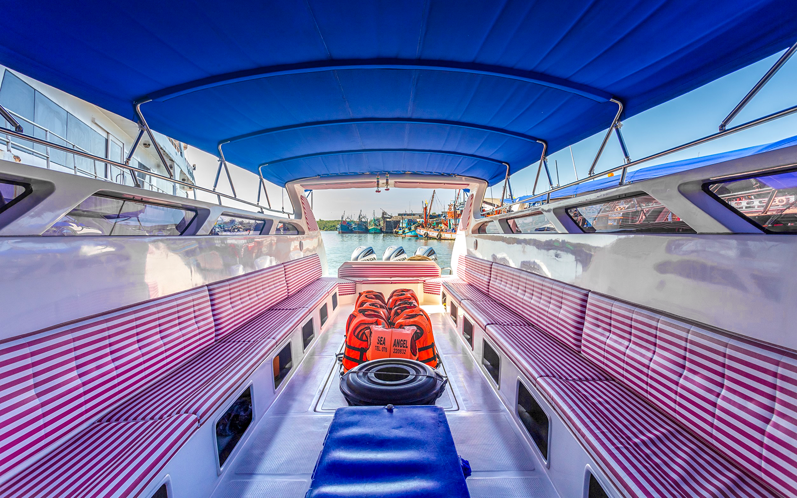 Speedboat interior with striped seats and life vests in Phuket.