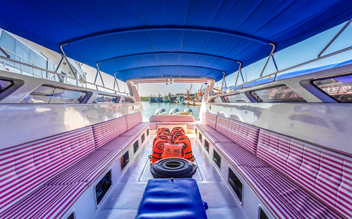 Speedboat interior with striped seats and life vests in Phuket.