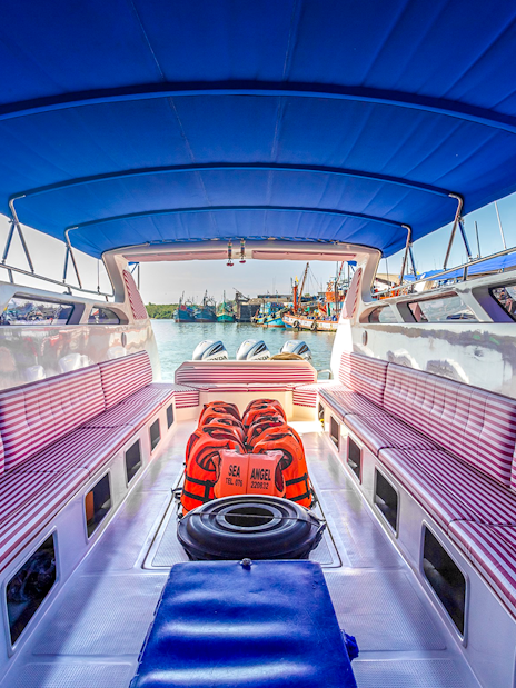 Speedboat interior with striped seats and life vests in Phuket.