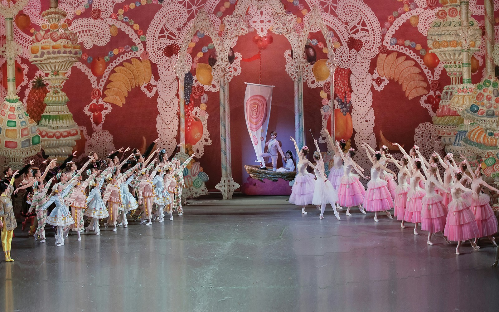 New York City Ballet dancers performing The Nutcracker with colorful candy-themed backdrop.