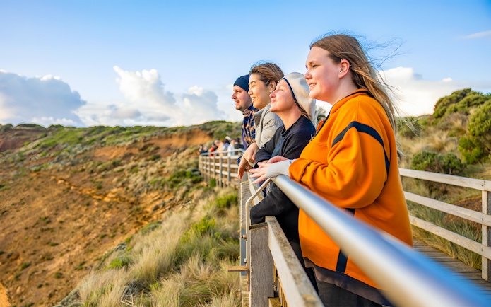 People enjoying sunset view at 12 Apostles lookout, Great Ocean Road tour.