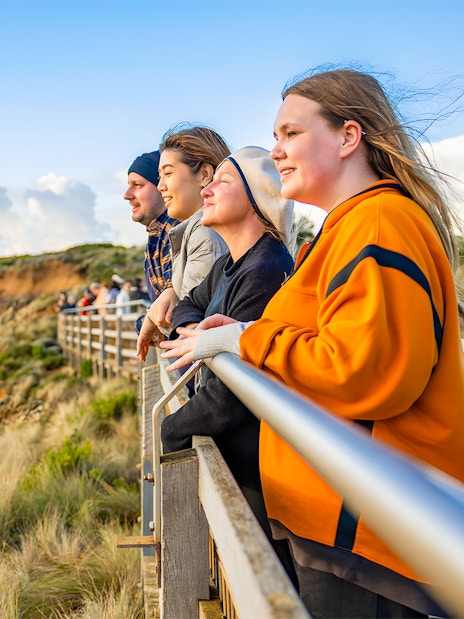 People enjoying sunset view at 12 Apostles lookout, Great Ocean Road tour.