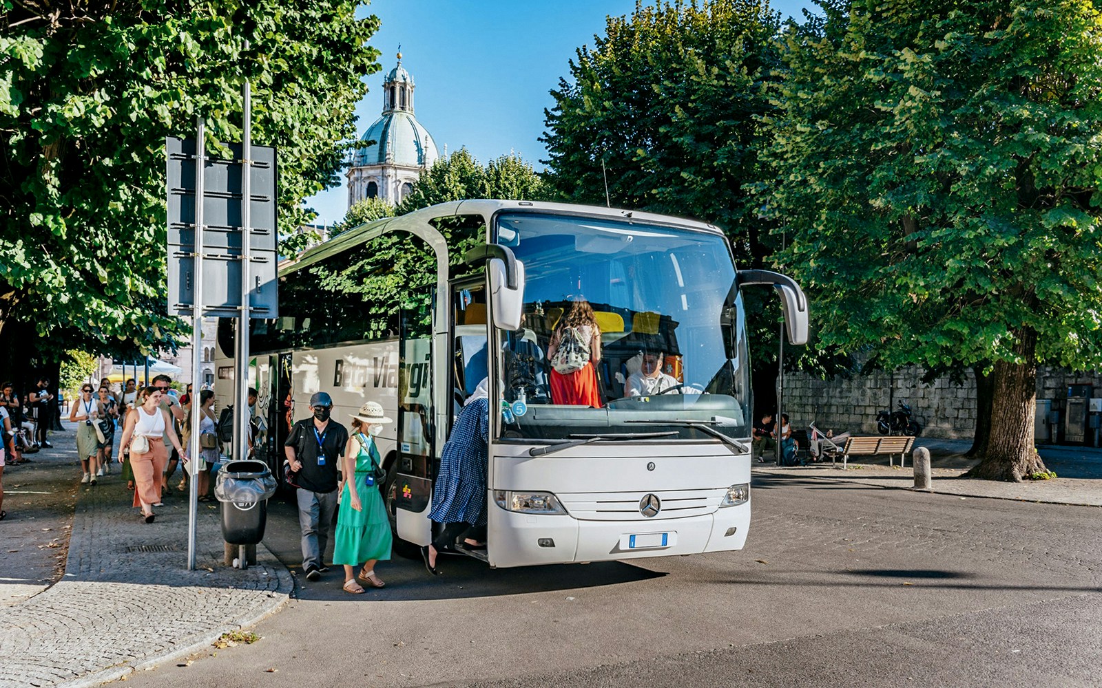 Tourists boarding a bus for a day trip to Lake Como, Bellagio, and Lugano.