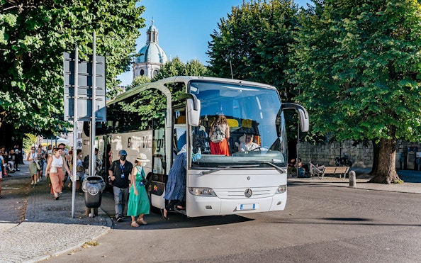 Tourists boarding a bus for a day trip to Lake Como, Bellagio, and Lugano.