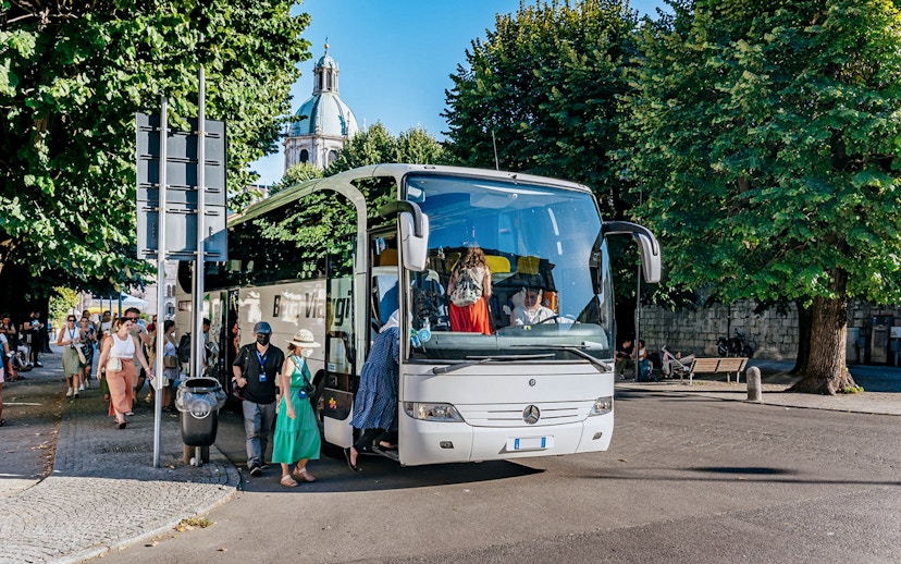 Tourists boarding a bus for a day trip to Lake Como, Bellagio, and Lugano.