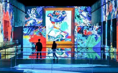 Visitors viewing Matisse artwork projection at Bassins Des Lumieres exhibition.
