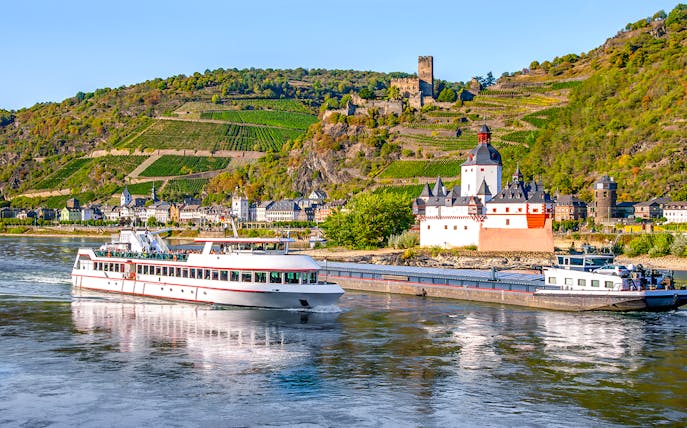 Pfalzgrafenstein Castle on Rhine River with passing tour boat, Germany.