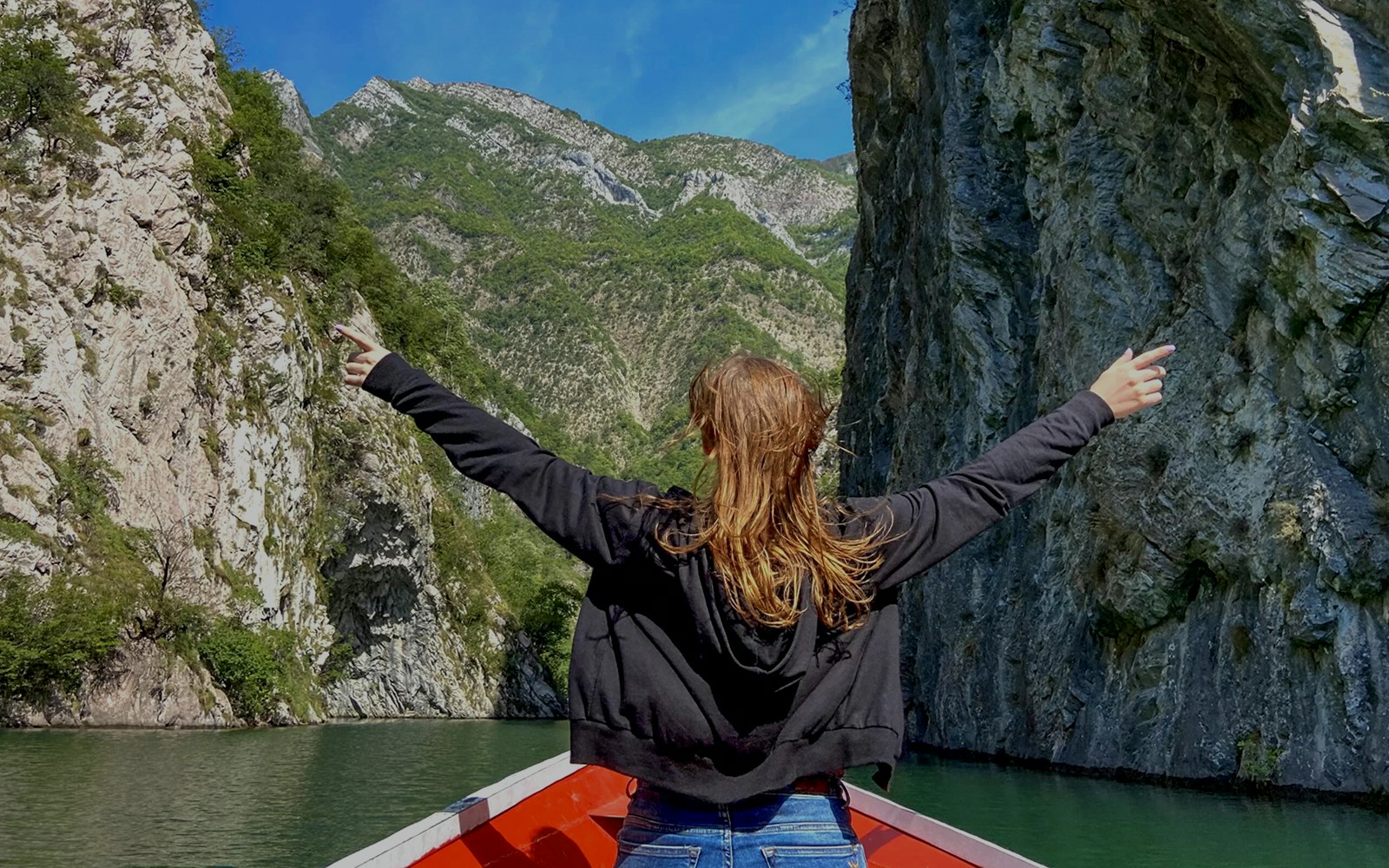 Guests on a boat ride through Shala River and Komani Lake, surrounded by steep cliffs.