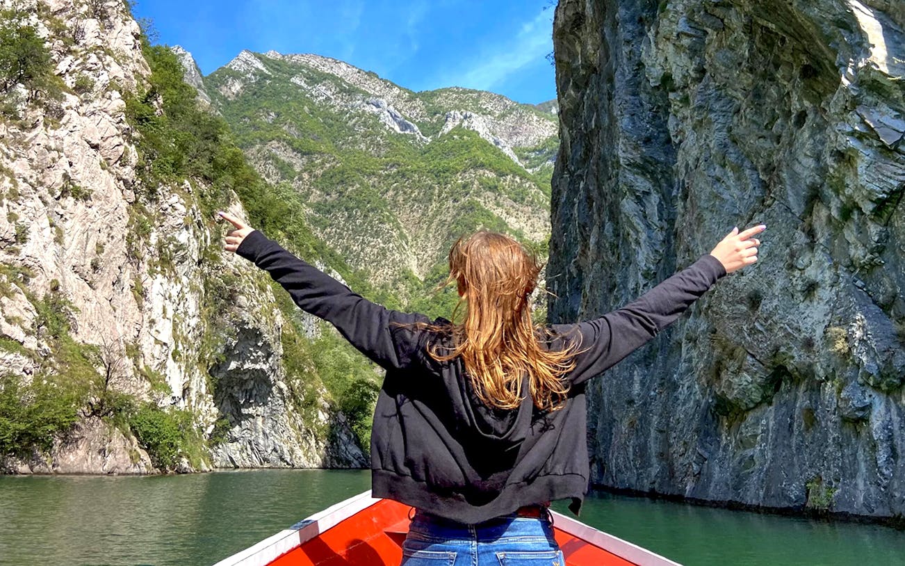 Guests on a boat ride through Shala River and Komani Lake, surrounded by steep cliffs.