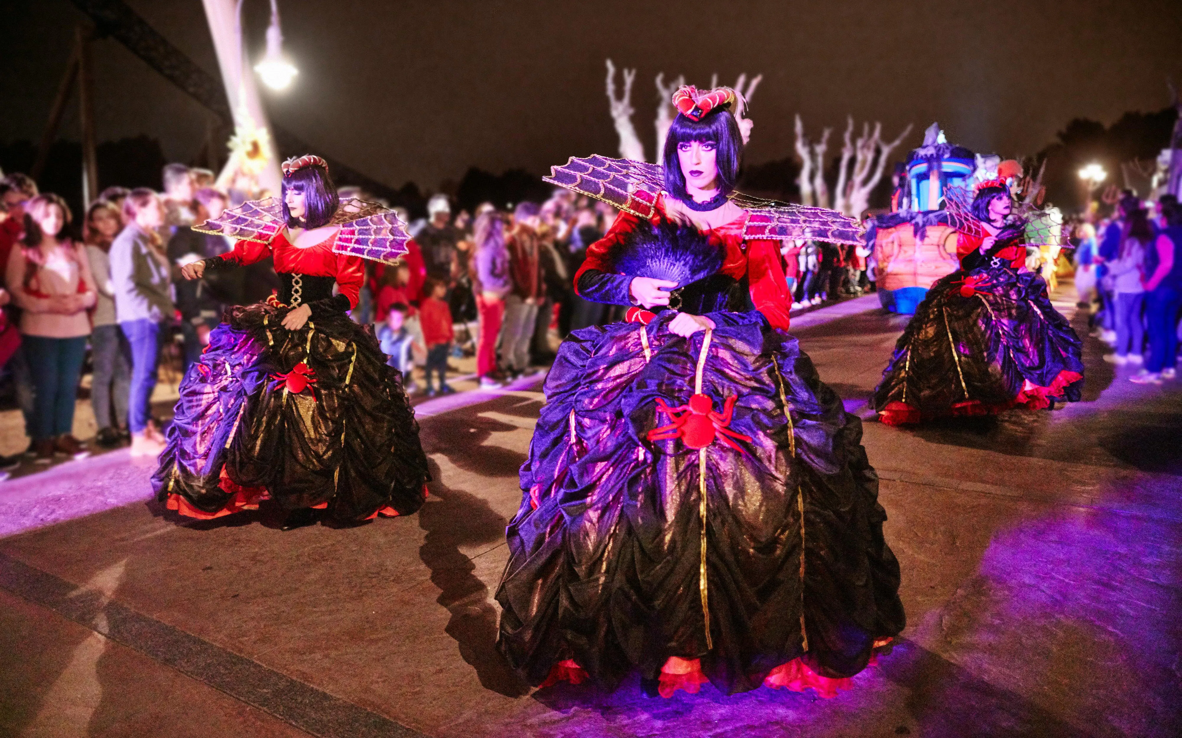 Performers in Halloween costumes at PortAventura Park parade at night.
