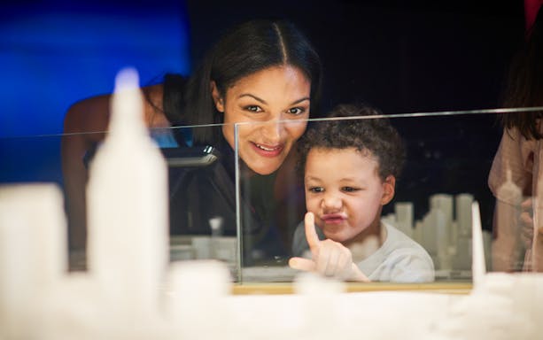 Child and adult exploring Melbourne Skydeck model, engaging in interactive exhibit.