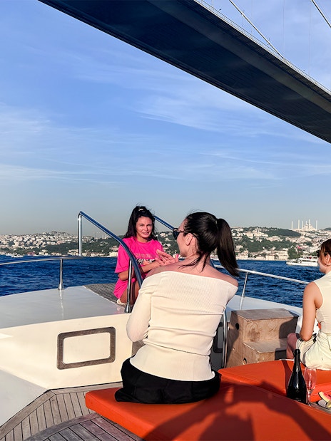 Passengers on a yacht viewing the Bosphorus Bridge in Istanbul.