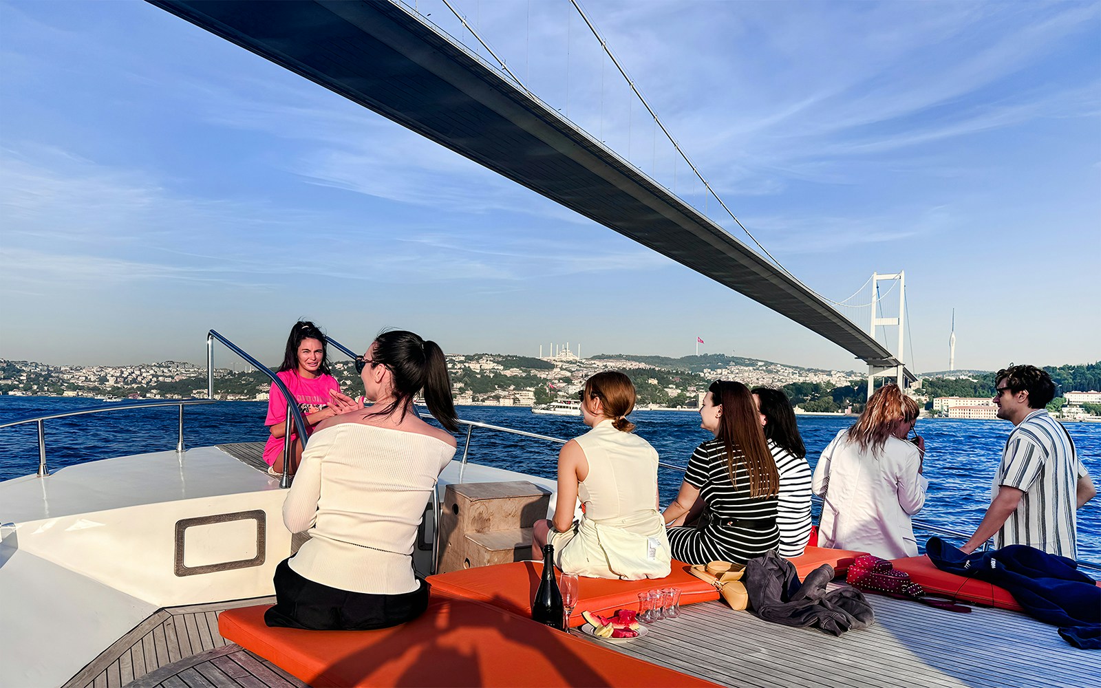 Passengers on yacht viewing Bosphorus Bridge in Istanbul.