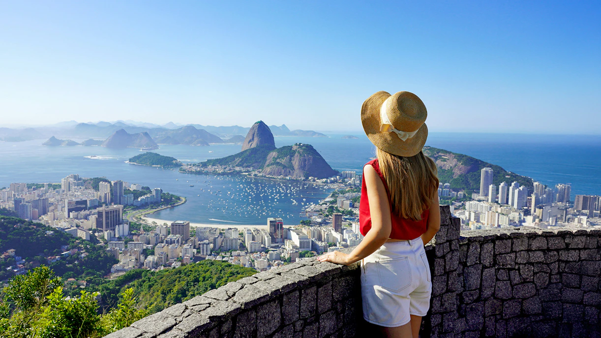 Traveler girl overlooking Guanabara Bay with Sugarloaf Mountain in Rio de Janeiro.