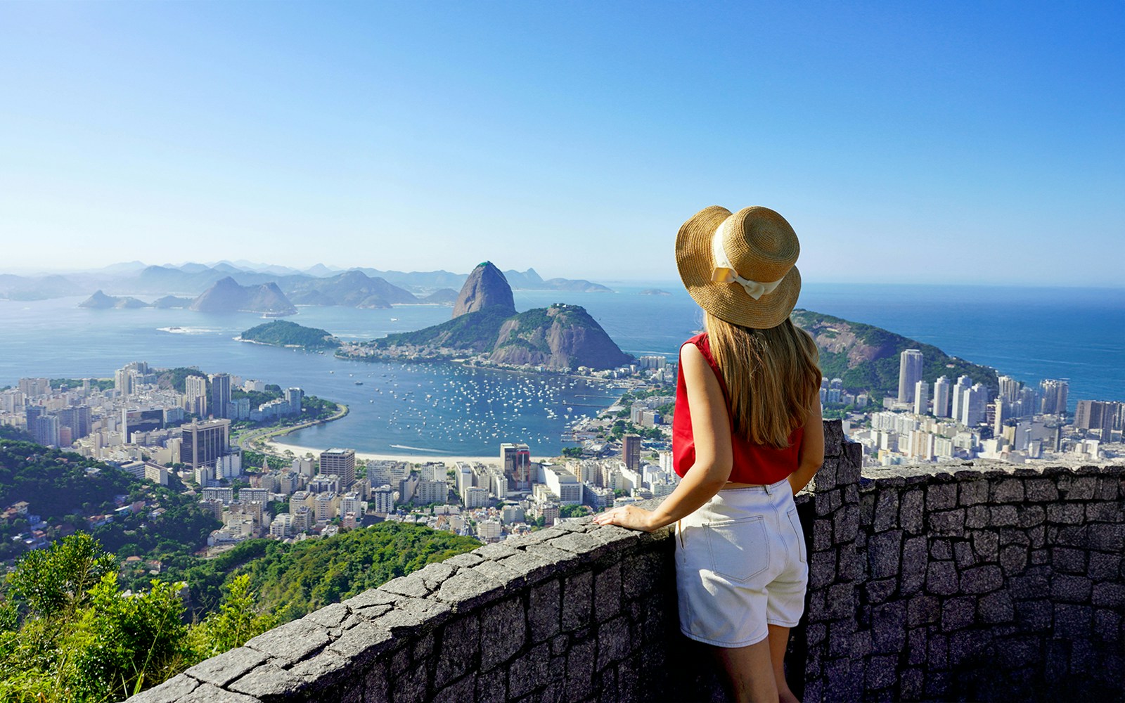 Traveler girl overlooking Guanabara Bay with Sugarloaf Mountain in Rio de Janeiro.