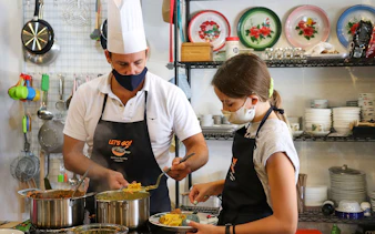 Chef and participant preparing dishes during Market to Table Culinary Tour Experience.