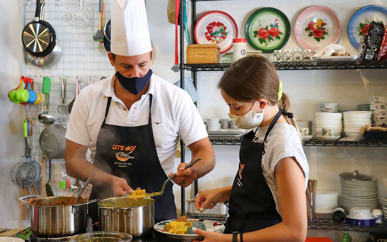 Chef and participant preparing dishes during Market to Table Culinary Tour Experience.