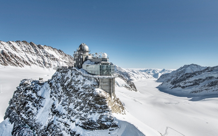 Sphinx Observatory perched on snowy peak at Jungfraujoch, surrounded by Swiss Alps.