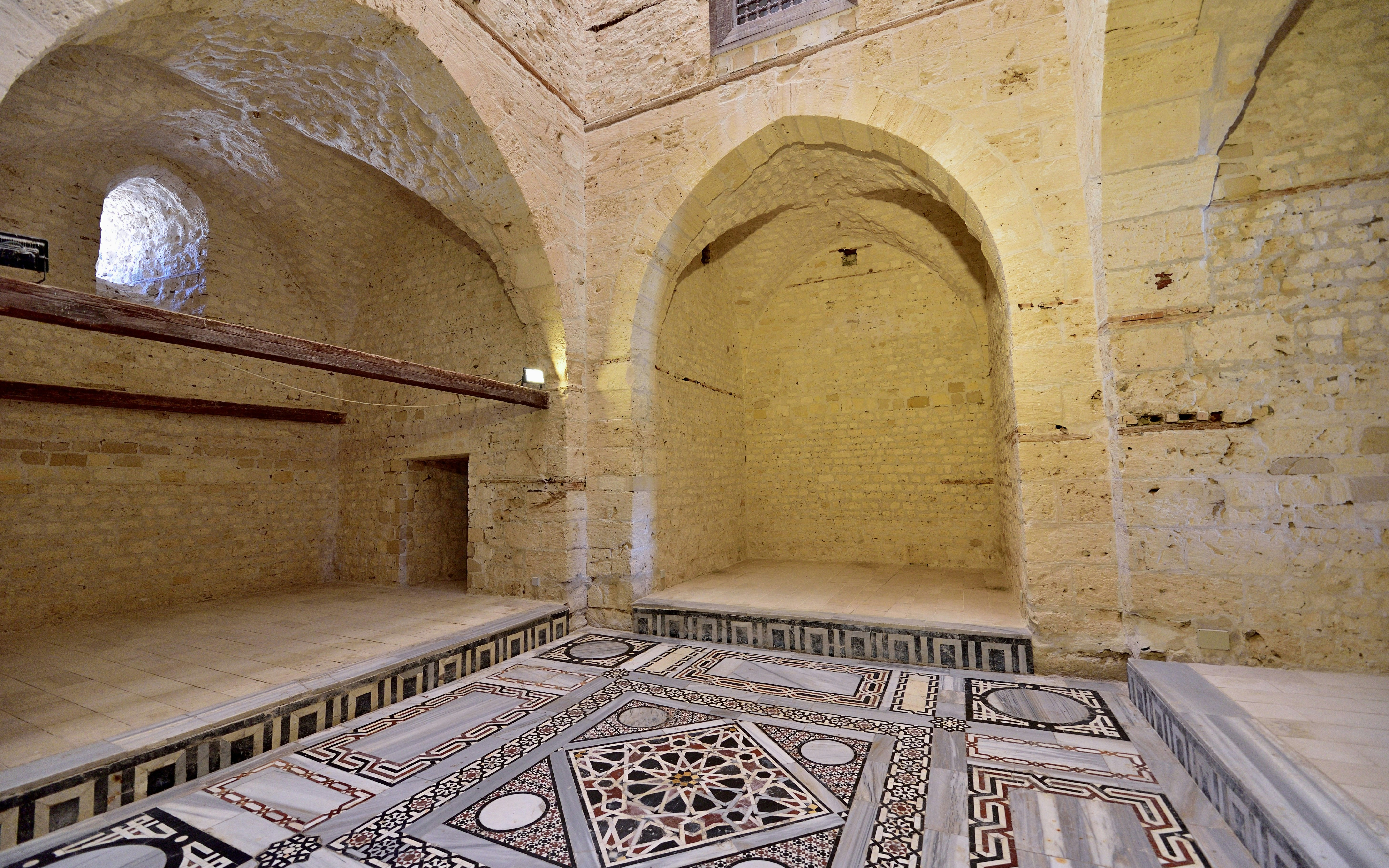 Interior of the Mosque inside the Citadel of Qaitbay, featuring intricate stonework and arches.