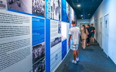 Visitors exploring the history wall during the OM Stadium tour.