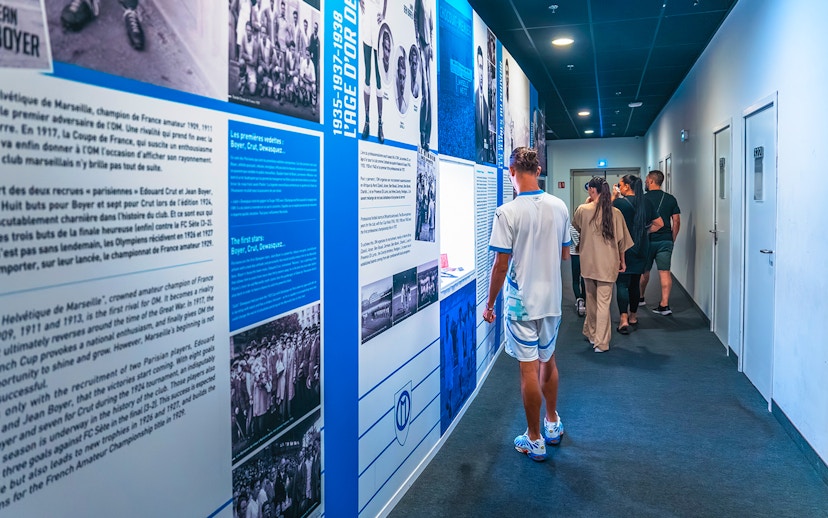 Visitors exploring the history wall during the OM Stadium tour.