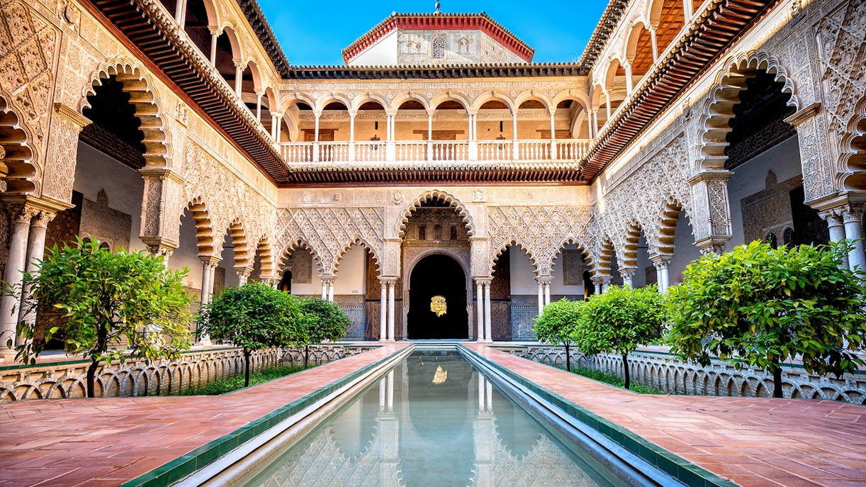 Courtyard with reflecting pool and arches at Alcazar Seville.