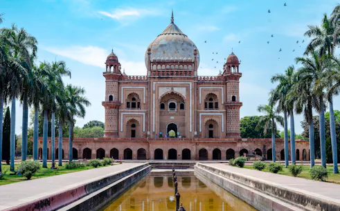 Safdarjung Tomb in Delhi with palm trees and reflecting pool.
