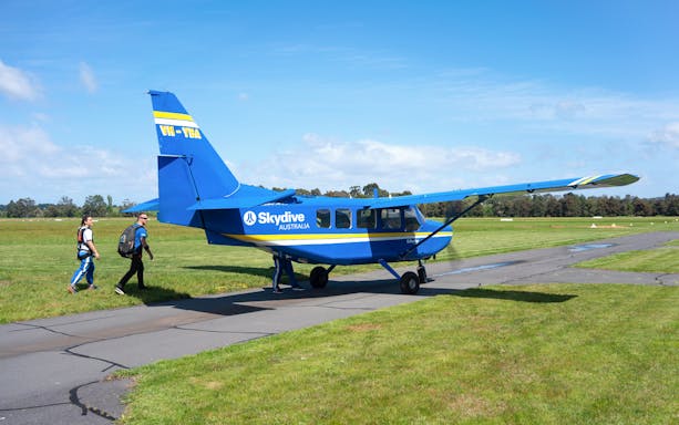 Skydivers walking towards a blue plane for a tandem skydive in Yarra Valley, Melbourne.