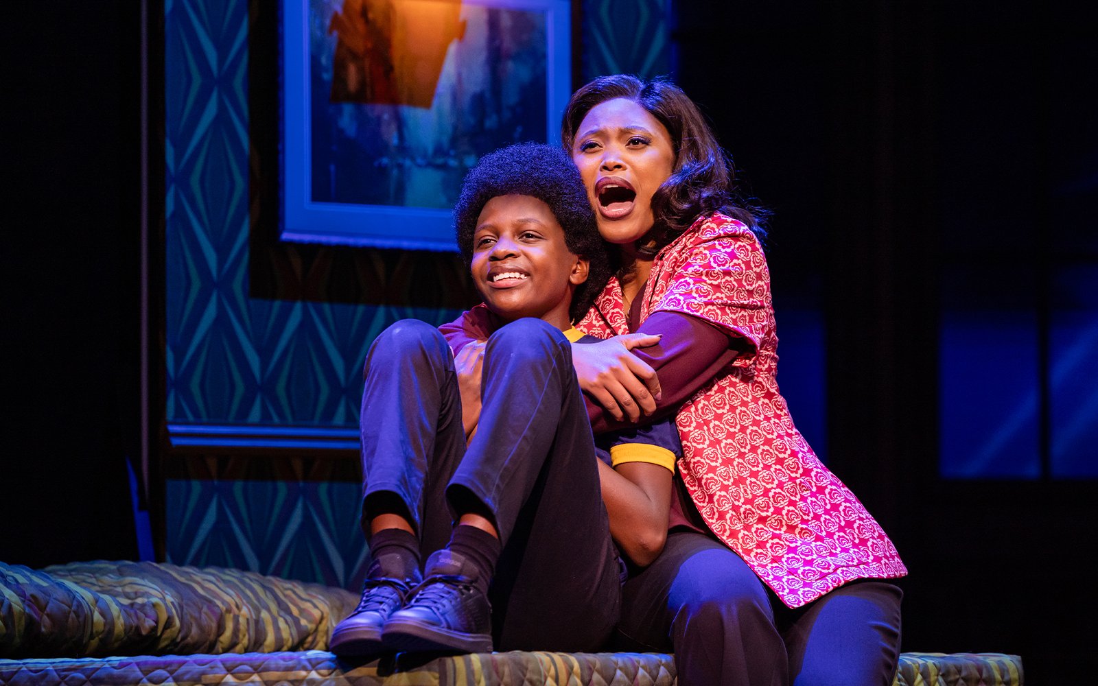 Stage scene from MJ the Musical in Brisbane, featuring two actors embracing on a bed.