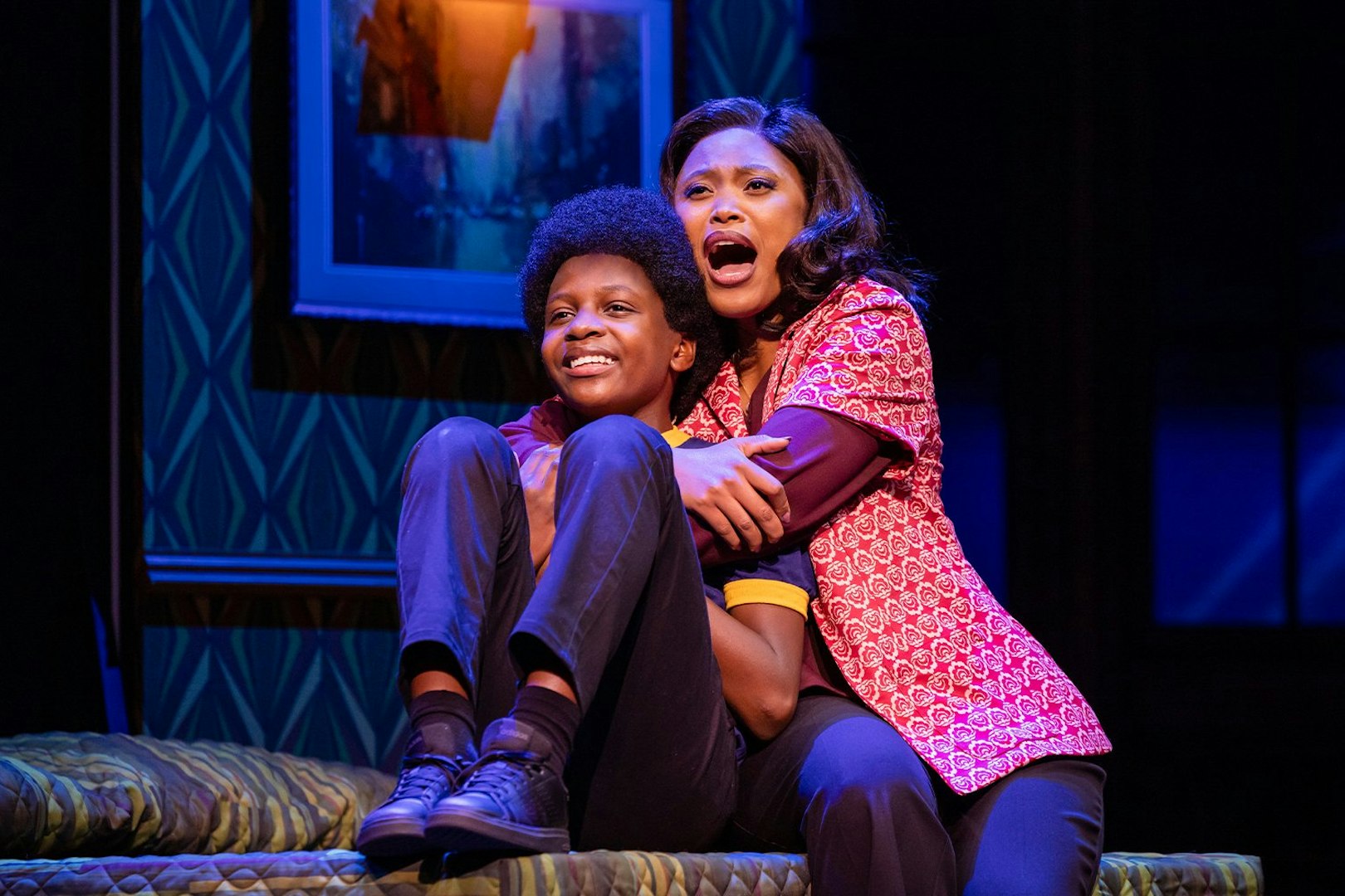 Stage scene from MJ the Musical in Brisbane, featuring two actors embracing on a bed.