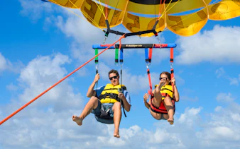 Parasailing over Miami with blue sky and clouds in the background.